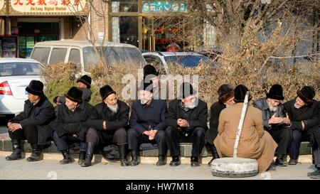 La Chine, la région autonome ouïghoure du Xinjiang, Kashgar (Kashi), groupe d'hommes discutant près de la mosquée Banque D'Images