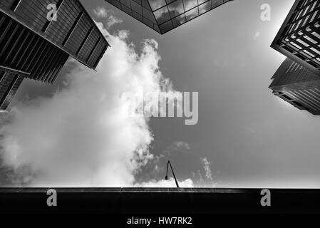 Une image générique anonyme monochrome regardant le ciel dans un fossé étroit entre les tours de bureaux en verre à Sydney, en Australie Banque D'Images