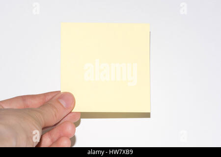Stick note isolé sur fond blanc. Post-it jaune avec Main sur fond blanc Banque D'Images