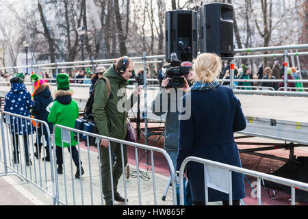 Moscou, Russie. Samedi 18 Mars, 2017. 25e jubilé Saint Patrick's Day Parade a lieu dans le parc Sokolniki de Moscou dans le cadre de la Semaine irlandaise festival 2017 du 15 au 26 mars. Le défilé est un événement culturel populaire et joyeuse à Moscou. L'Église orthodoxe russe (ROC) a reconnu Saint Patric récemment et à partir de maintenant sur ROC célébrera le jour de Saint Patrick officiellement. Non identifié, méconnaissable, belle dame de la télévision les rapports correspondants des nouvelles de la zone du festival au parc Sokolniki. © Alex's Pictures/Alamy Live News Banque D'Images