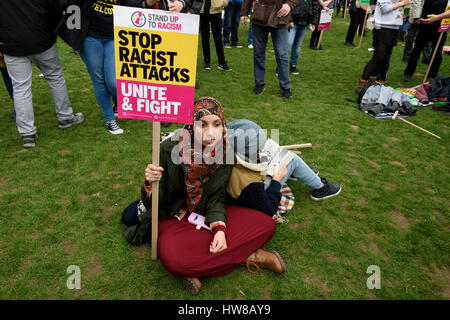 Femme musulmane est un manifestant Anti-racisme holding a placard lecture : 'Stop des attaques racistes, s'unir et lutter contre le racisme des Nations Unies lors de la journée à Londres, Royaume-Uni. Banque D'Images