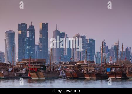Qatar, Doha, les dhows sur la baie de Doha West Bay avec des gratte-ciel, crépuscule Banque D'Images
