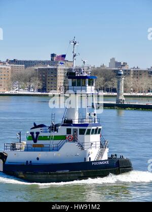 Tugboat passe le phare de l'Île Roosevelt sur l'East River, Upper Eastside, New York, New York, USA. Banque D'Images