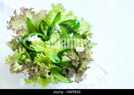 Salade de légumes verts mixtes organiques de feta et pois de printemps à bol en bois close up - Alimentation saine aliments végétariens vegan Bio salade repas Banque D'Images