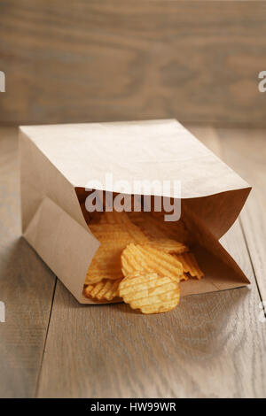 Chips de pomme de terre ridée de paprika en sac de papier Banque D'Images