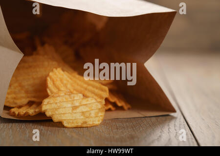 Chips de pomme de terre ridée de paprika en sac de papier Banque D'Images