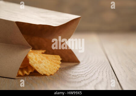 Chips de pomme de terre ridée de paprika en sac de papier Banque D'Images