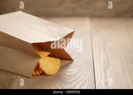 Chips de pomme de terre ridée de paprika en sac de papier Banque D'Images