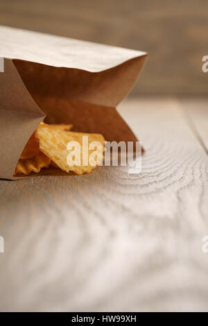 Chips de pomme de terre ridée de paprika en sac de papier Banque D'Images