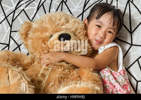 Petite fille asiatique chinois avec des ours en peluche à la maison Banque D'Images