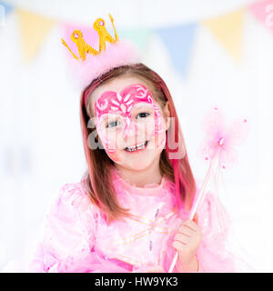 La peinture du visage de petite fille. Princesse et conte de thème d'anniversaire avec la peinture pour le visage de l'artiste et costume pour enfant d'âge préscolaire. Enfants célébrant Hallow Banque D'Images