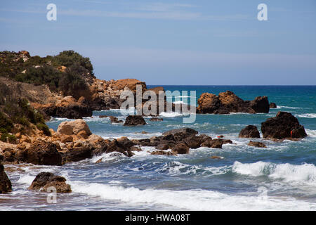 Vagues se brisant sur des rochers à la plage de San Blas Gozo, Malte Banque D'Images