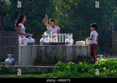 Le Myanmar, Birmanie, Mrauk U, jeunes filles choisir l'eau du puits Banque D'Images