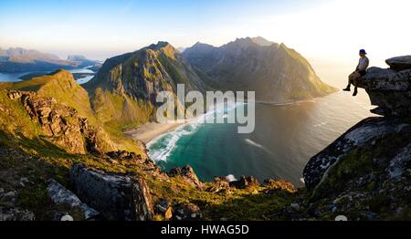 La Norvège, Nordland, îles Lofoten, Moskenesoy island, Randonneur au sommet du mont Ryten (543m), la plage isolée de Kvalvika ci-dessous Banque D'Images