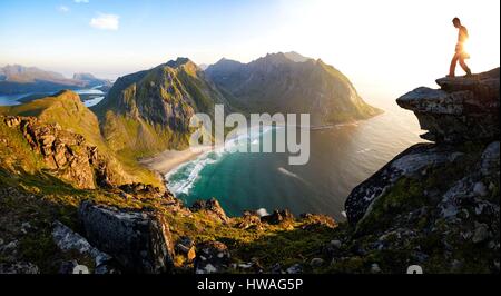 La Norvège, Nordland, îles Lofoten, Moskenesoy island, Randonneur au sommet du mont Ryten (543m), la plage isolée de Kvalvika ci-dessous Banque D'Images