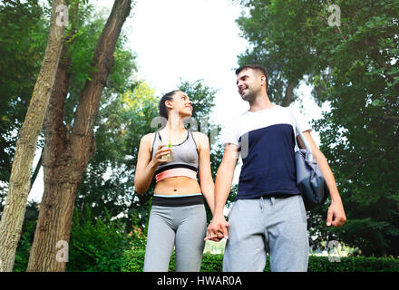 Happpy jeunes couple en train de marcher dans le parc après l'activité sportive Banque D'Images