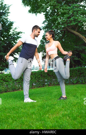 Jeune couple exercising happpy et étirer les muscles avant l'activité sportive Banque D'Images