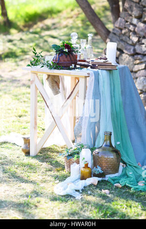 Cocolate gâteau décoré de fleurs et de trois carafes de whisky contre un arrière-plan gris clair avec copie espace Banque D'Images