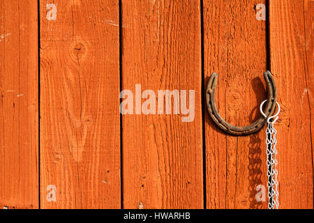 Old rusty horseshoe suspendu par une porte en bois brun Banque D'Images