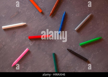 Des crayons dans un désordre organisé sur fond sombre Banque D'Images