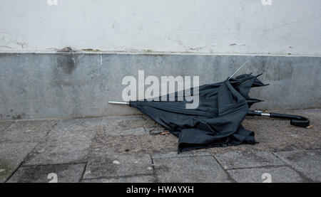 Parapluie noir cassé est jeté à la poubelle et se trouve comme abandonnés dans la rue Banque D'Images