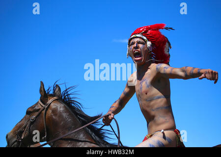 Native American Indian wearing blue peinture de la guerre et le port de tête de cérémonie red feather dress reenactor Crazy Horse à la bataille de Little Bighorn, Montana Banque D'Images