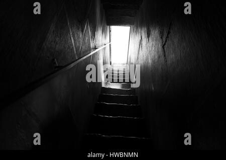 Escalier en noir et blanc. Belle photo de mystique étapes sombres en escalier menant à la porte à la lumière. Fine art poétique magnifique image. Calme et paisible Banque D'Images