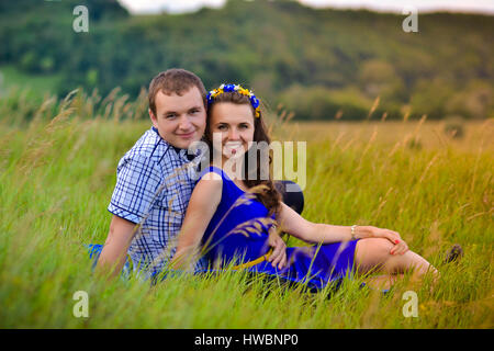 Cheerful,belle,smiling couple heureux,jeune famille sur date.heureux,jeune couple regardant le coucher du soleil sur le vert prairie ensoleillée.heureux,joyeuse,souriante jeune fam Banque D'Images