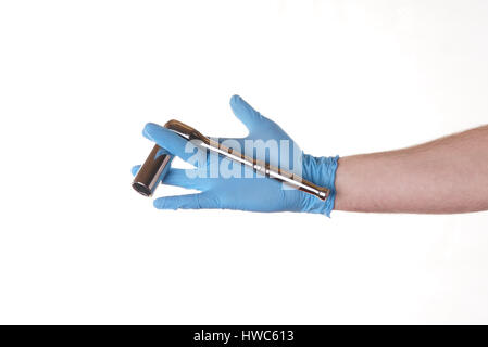 Stock Photo - main tenant une clé à cliquet avec prise isolé sur blanc, bleu gant de nitrile Banque D'Images