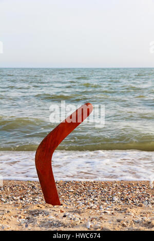 Boomerang sur plage de sable contre des vagues de la mer et ciel bleu prise libre. Banque D'Images