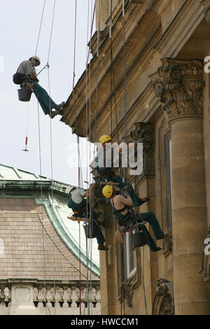 Tailleurs sur des cordes et harnais de la restauration et la réparation de maçonnerie sur une façade à Budapest, Hongrie. Banque D'Images