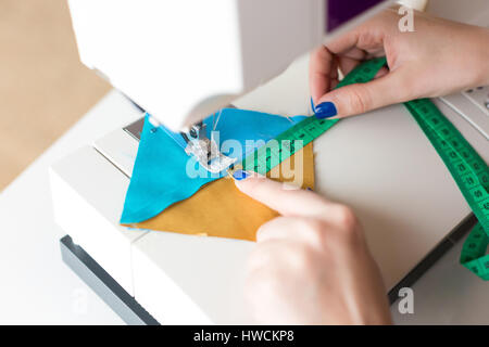 Femmes griffonnés sur la machine à coudre couleur géométrique pièces de tissu pour patchwork. Le concepteur à mains à la machine à coudre de près. Banque D'Images