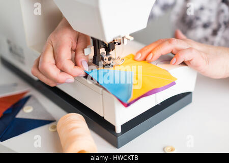 Femmes griffonnés sur la machine à coudre couleur géométrique pièces de tissu pour patchwork. Le concepteur à mains à la machine à coudre de près. Banque D'Images