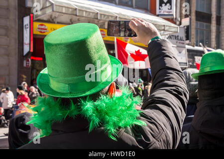 Montréal, Canada - 19 mars 2017 : Un spectateur portant un chapeau vert prend des photos de st. Patrick's parade Banque D'Images