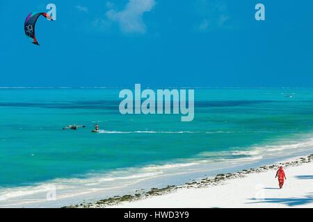 La Tanzanie, Zanzibar, Jambiani, voilée femme marche sur une plage de sable blanc baignée par les eaux turquoise Banque D'Images