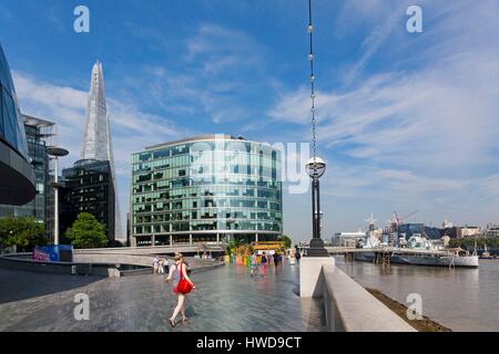 Royaume-uni, Londres, quartier de Southwark, les rives de la Tamise près de Tower Bridge, le gratte-ciel le fragment par l'architecte Renzo Piano, le navire de guerre HMS Belfast amarré sur la rivière, jeune femme avec sac à main rouge Banque D'Images