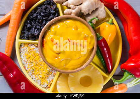 Bol de sauce curry de légumes et d'ingrédients qui entrent dans la rendant - paprika, piment, carotte, ananas, gember. Largement utilisé dans la cuisine indienne. Banque D'Images