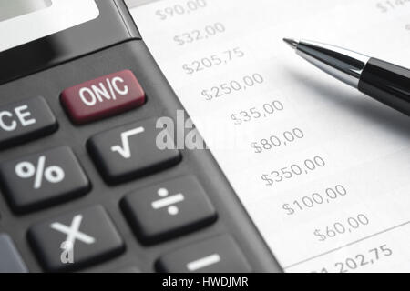 Stylo à bille, document imprimé et une grande calculatrice sur la table Banque D'Images