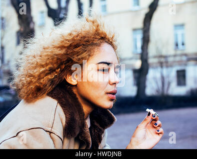 Jeune jolie fille à l'extérieur d'adolescent cigarette close up, ressemblant à du vrai junky, questions sociales concept Banque D'Images