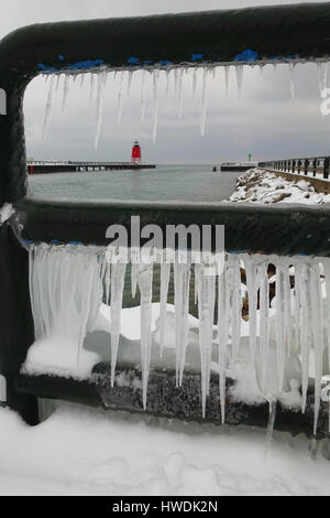 Regardant à travers un glaçon rempli lors d'une balustrade phare rouge sous un ciel couvert, journée d'hiver. Banque D'Images