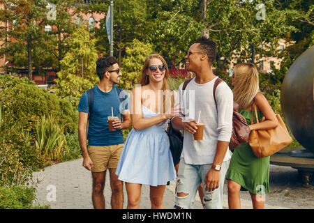 Cinq amis adultes se promener ensemble dans park Banque D'Images