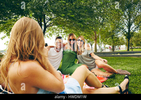 Au cours de l'épaule en photographiant les amis pique-nique dans le parc Banque D'Images