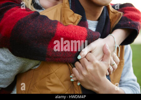 Close up Portrait of woman hugging and holding boyfriend's hands Banque D'Images