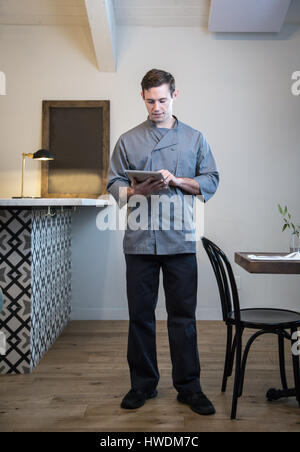 Portrait de serveur dans un restaurant, using digital tablet Banque D'Images