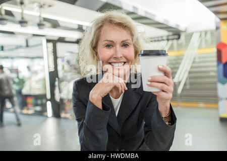 Portrait de femme mature avec du café à emporter dans shopping mall cafe Banque D'Images