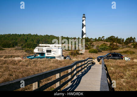 NC00891-00...CAROLINE DU NORD - voitures qui passent le cap Lookout Phare sur la route à travers les dunes de sable de la région de Cape Lookout National Seashore. Banque D'Images