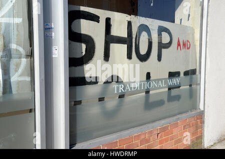 Shop soit par le signe dans une vitrine. Banque D'Images