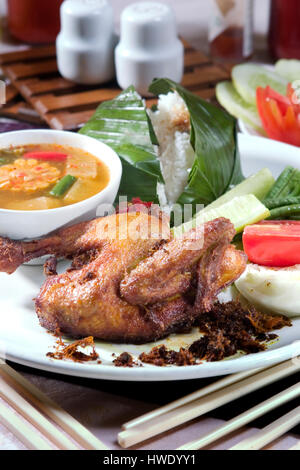 Ayam goreng Indonésie alimentaire poulet frit, servir avec un plat de tamarin, sayur asam et riz Banque D'Images