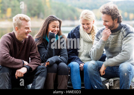 Smiling friends enjoying camping sur Lakeshore Banque D'Images