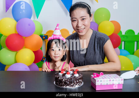 Petite fille asiatique chinois et mère célébrer Anniversaire en jeu intérieur Banque D'Images
